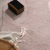 A close-up view of a pink rug with a stack of books and a folded blanket on it. Voir les images du produit