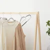 Clothing hangers with sweaters on a wooden rack. Náhled obrázku produktu