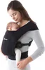 A woman is holding a baby in a black baby carrier. Produktbild-Vorschau