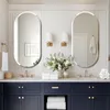 A modern bathroom vanity with two oval mirrors above it, featuring sinks, faucets, and decorative elements like flowers and towels. Podgląd zdjęcia produktu