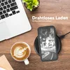 A desk scene with a laptop, coffee, and a smartphone charging wirelessly. Produktbild-Vorschau