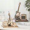 A wooden model of an electric guitar and a violin are displayed on a table. Voir les images du produit
