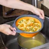 Hands holding a collapsible strainer filled with tri-color fusilli pasta over a pot of boiling water in a sink. Anteprima dell’immagine prodotto