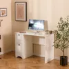 A white desk with a computer monitor, keyboard, and a small radio sits in a room with light beige walls and wooden flooring. Anteprima dell’immagine prodotto
