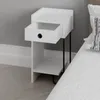 A white bedside table with an open drawer next to a bed. Podgląd zdjęcia produktu