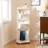 A white laundry cart with three baskets is placed in a room with a window and a cabinet. Produktbild-Vorschau