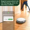 A robot vacuum cleaner is shown on a wooden floor next to a doorway, with a smartphone app interface overlaid on the left side of the image. Náhľad obrázku produktu