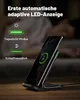 A person is sleeping in the background while a wireless charger with a phone on it is in the foreground. Produktbild-Vorschau