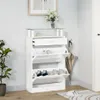 A white shoe cabinet with three flip-down compartments and a drawer, next to a potted plant and a vase of flowers on a shelf. Anteprima dell’immagine prodotto