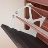 A white plastic jig is shown being used to install a wooden shelf into a cabinet. The jig has two numbered points indicating where to align it. Produktbild-Vorschau