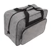 A gray sewing machine storage bag with black handles and zippers, shown from a slightly elevated angle against a white background. Náhľad obrázku produktu