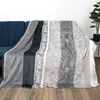 A blanket is draped over a blue sofa, with a plant in a pot visible in the background. Produktbild-Vorschau
