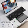 A foldable wireless keyboard and touchpad are shown on a desk next to a tablet. Produktbild-Vorschau