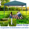 A family is having a picnic under a green pop-up gazebo in a grassy park. Produktbild-Vorschau