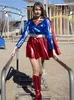 A woman in a Supergirl costume on a playground. Produktbild-Vorschau