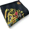A folded blanket with the Hogwarts crest and house emblems. Anteprima dell’immagine prodotto