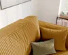 A close-up view of a mustard-yellow corduroy sofa with two throw pillows, one green and one mustard-yellow. Náhled obrázku produktu