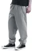 A person wearing grey sweatpants and black sneakers, shown from the waist down. Produktbild-Vorschau