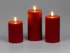 Three red LED candles of varying heights are arranged on a light gray surface. Produktbild-Vorschau