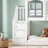 A close-up view of a white bunk bed with stairs that have drawers, a window detail on the upper bunk, and stuffed animals on the lower bunk. Produktbild-Vorschau