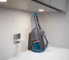 A cordless handheld vacuum cleaner is shown on a charging dock next to a wall outlet. Produktbild-Vorschau