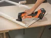 A person is using a power tool to sand a wooden window frame. Produktbild-Vorschau