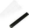 A white sheet of paper is positioned diagonally in the upper left of the frame, and a black cylindrical object is positioned diagonally in the lower right. Anteprima dell’immagine prodotto