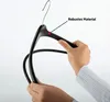 A hand holding a black clothes hanger. Produktbild-Vorschau