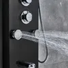 A close-up view of a black shower panel with chrome fixtures, showing water spraying from two of the showerheads. Náhľad obrázku produktu