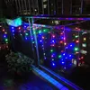 A balcony at night decorated with colorful icicle string lights. Produktbild-Vorschau