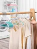 A collection of hangers with clothes hanging on a rack, with a washing machine and laundry supplies in the background. Produktbild-Vorschau