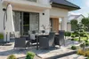 An outdoor patio setting with a dining set and landscaping. Náhľad obrázku produktu