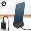 A blue iPhone is placed on a black charging dock, connected to a black charger plugged into a white power strip. Podgląd zdjęcia produktu