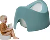 A young child sits on a potty training seat and holds a book. Produktbild-Vorschau