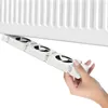 A hand is holding a white radiator fan booster device under a white radiator. Voir les images du produit