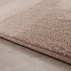 Close-up of a beige rug with a textured surface and a bound edge, resting on a light wooden floor. Produktbild-Vorschau