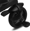 A close-up view of the wheel and pedals of a black tricycle. Produktbild-Vorschau