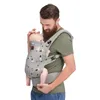 A man is holding a baby in a baby carrier. Náhled obrázku produktu