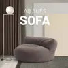 A modern living room scene with a large beanbag-style sofa, a floor lamp, and curtains. Náhľad obrázku produktu
