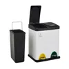 A white dual-compartment trash can with black lids and pedals, next to a black trash can insert. Produktbild-Vorschau