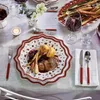A festive table setting with a Villeroy & Boch Toy's Delight plate filled with food, surrounded by cutlery, a wine glass, and decorative elements. Anteprima dell’immagine prodotto
