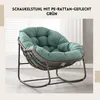 A green rocking chair with a thick cushion is shown in a room with a window in the background. Produktbild-Vorschau