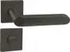 A black door handle set with a square rosette and a matching escutcheon plate is shown against a white background. Produktbild-Vorschau