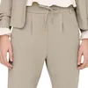Close-up of a person wearing beige pants and a beige jacket. Produktbild-Vorschau