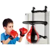 A young boy wearing boxing gloves is shown punching a boxing bag attached to a door. Podgląd zdjęcia produktu