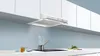 A modern kitchen scene with a range hood over a stovetop where food is cooking. Voir les images du produit