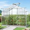 A greenhouse with tomato plants growing inside, set in a garden with a pathway leading to it. Produktbild-Vorschau