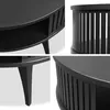 A collage of four close-up images of a black round coffee table, showing details of its design, legs, and slatted sides. Produktbild-Vorschau