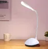 A white LED desk lamp with a flexible neck is shown on a wooden desk next to a mug. Produktbild-Vorschau