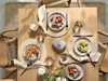 A beautifully set table for breakfast with plates of food, drinks, and cutlery. Produktbild-Vorschau